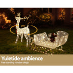 Warm-lit reindeer and sleigh outdoor decoration with 360-degree glowing ring and red bows