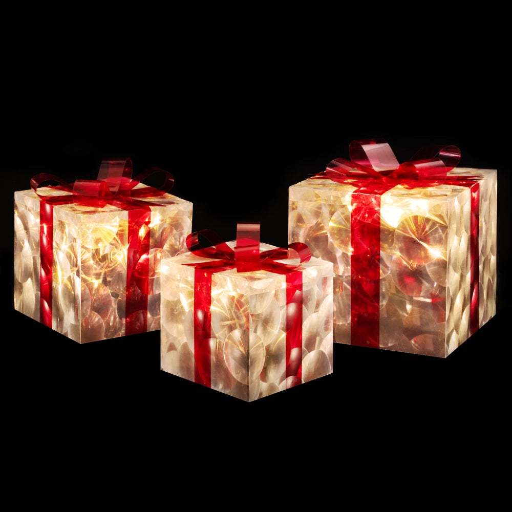 Set of illuminated LED fairy lights in clear gift boxes with red ribbon bows