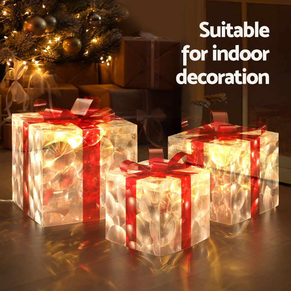 Warm-glowing LED lights inside clear gift boxes with red ribbon bows