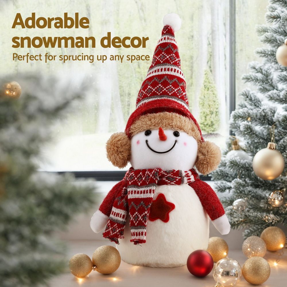 Plush snowman decoration wearing a red knit hat and plaid scarf with embroidered smile